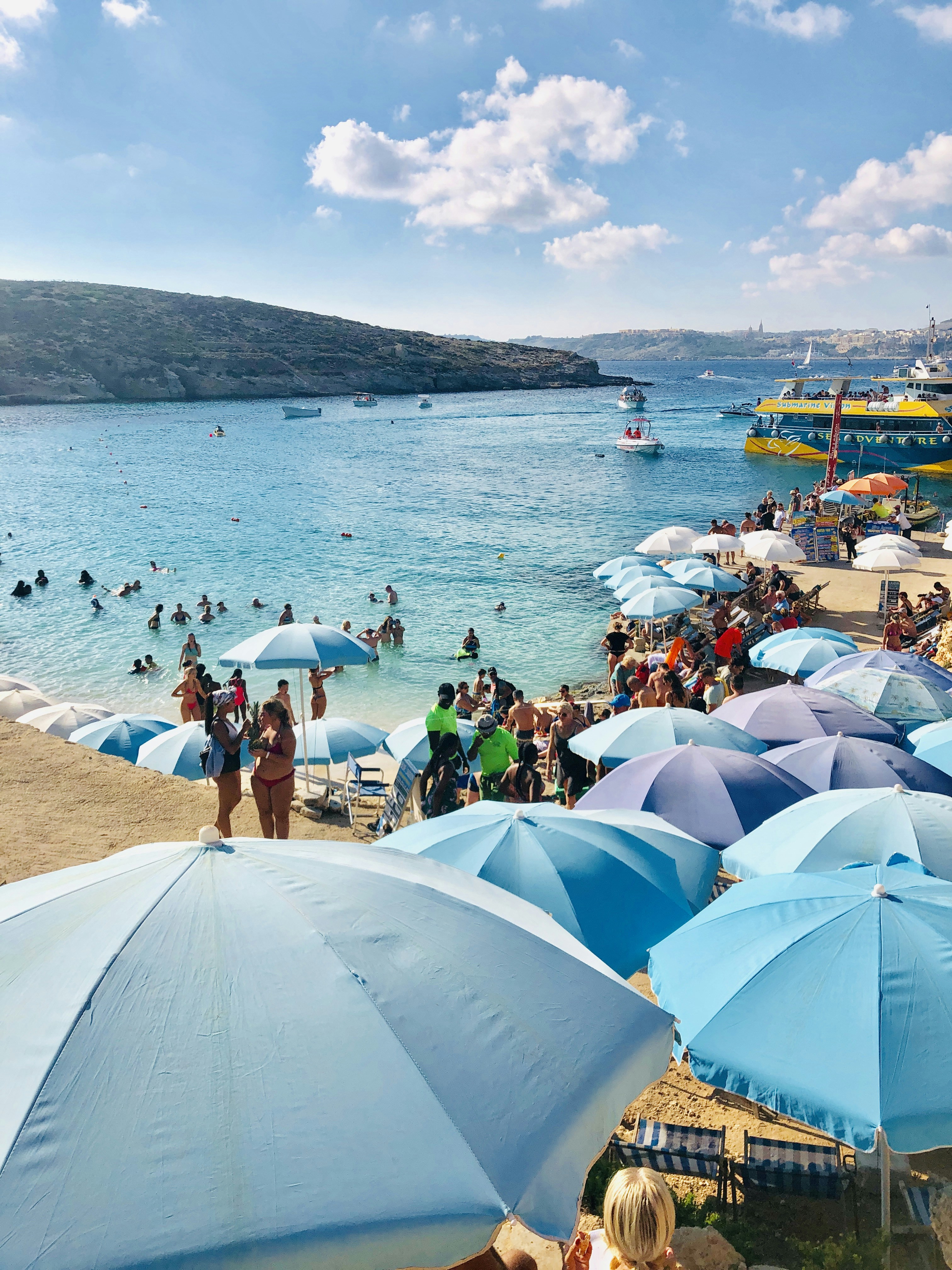A beach filled with lots of blue umbrellas photo Free Malta Image on