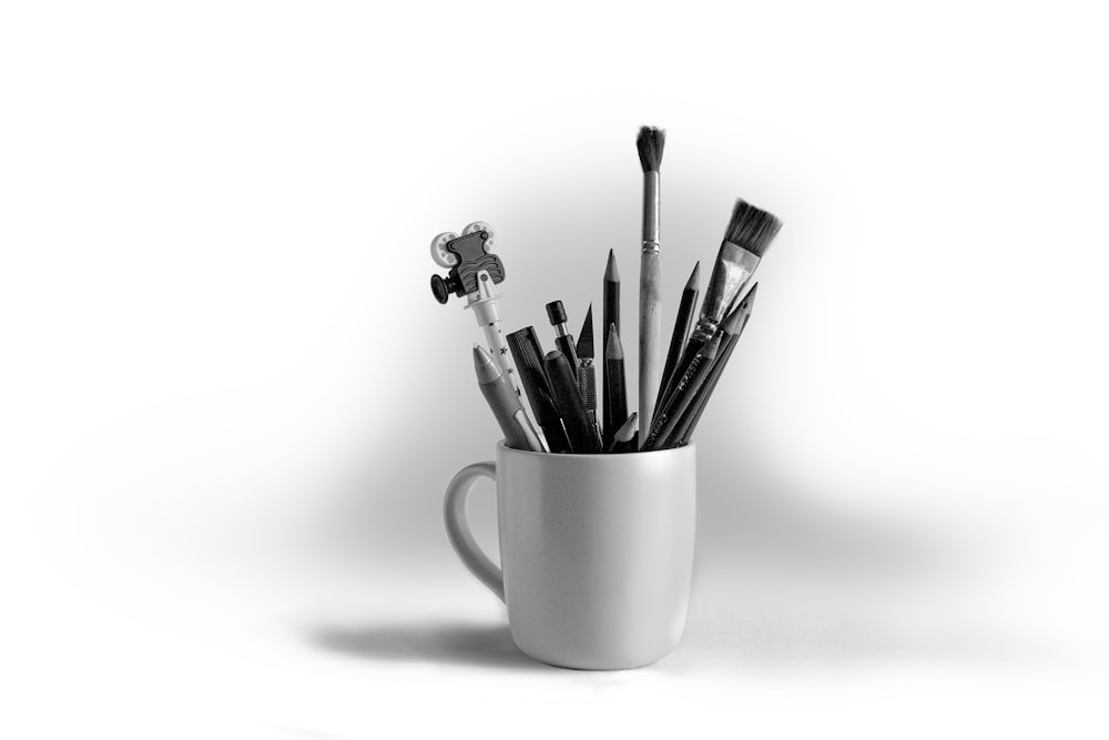 a cup filled with lots of different types of brushes