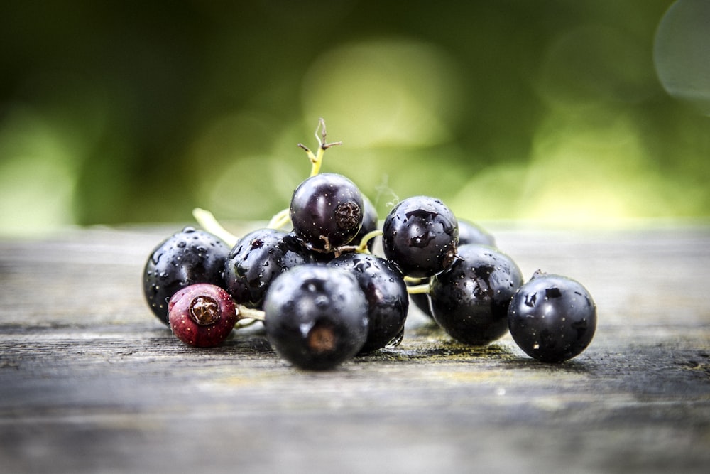 a bunch of black berries sitting on top of a wooden table