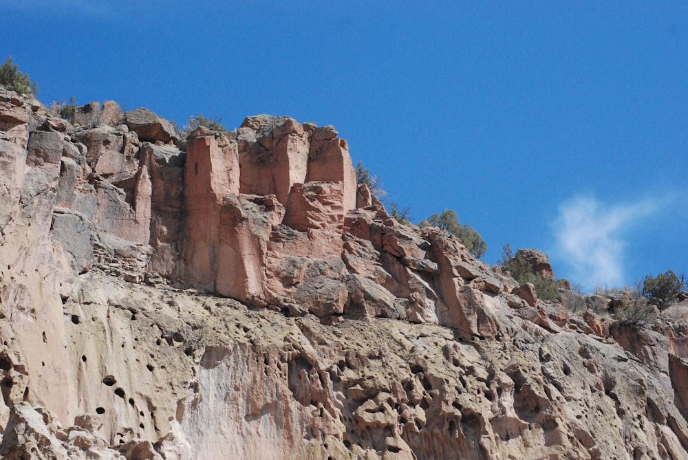 a mountain side with some rocks and trees