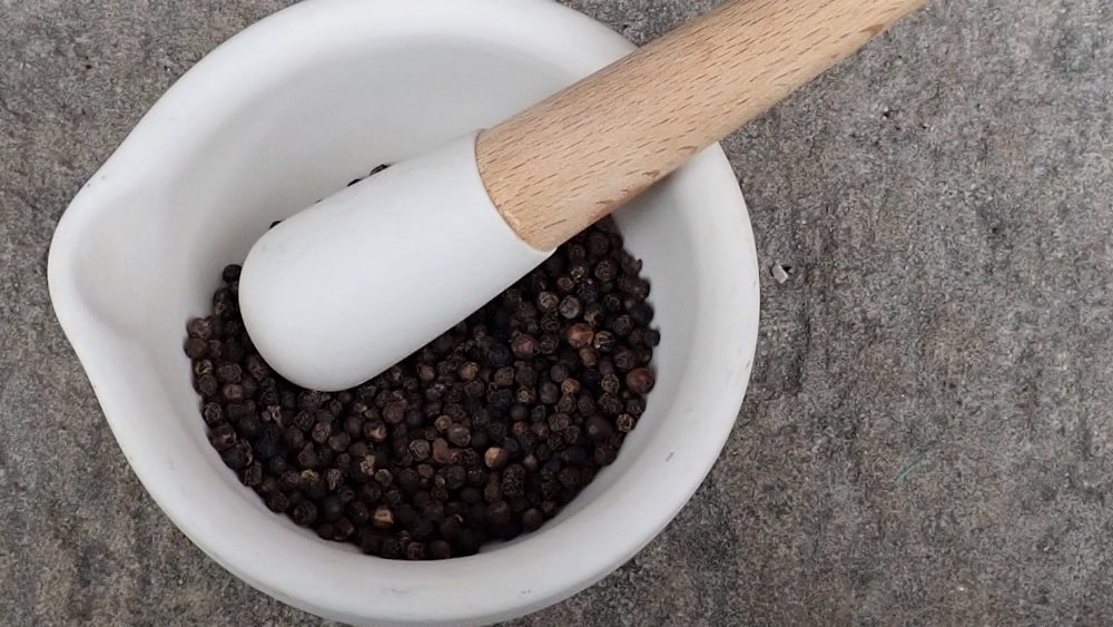 a white bowl with a wooden spoon in it