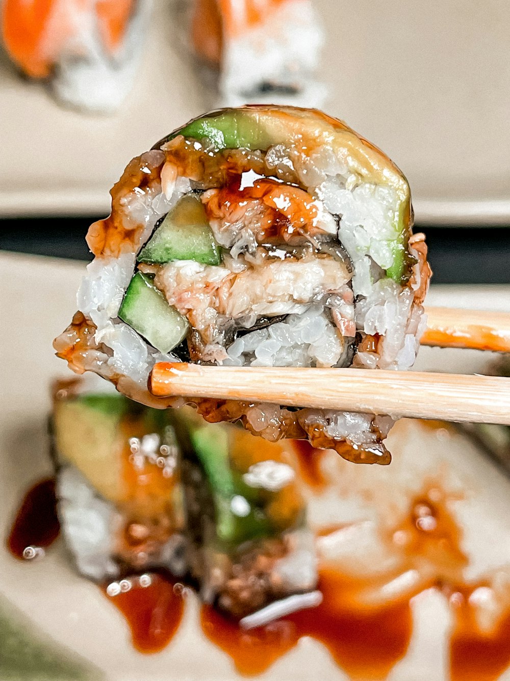 a close up of a sushi on a plate with chopsticks