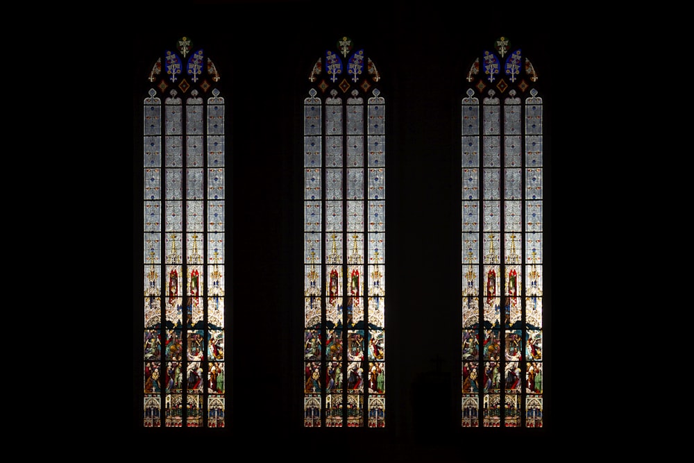 two stained glass windows in a dark room