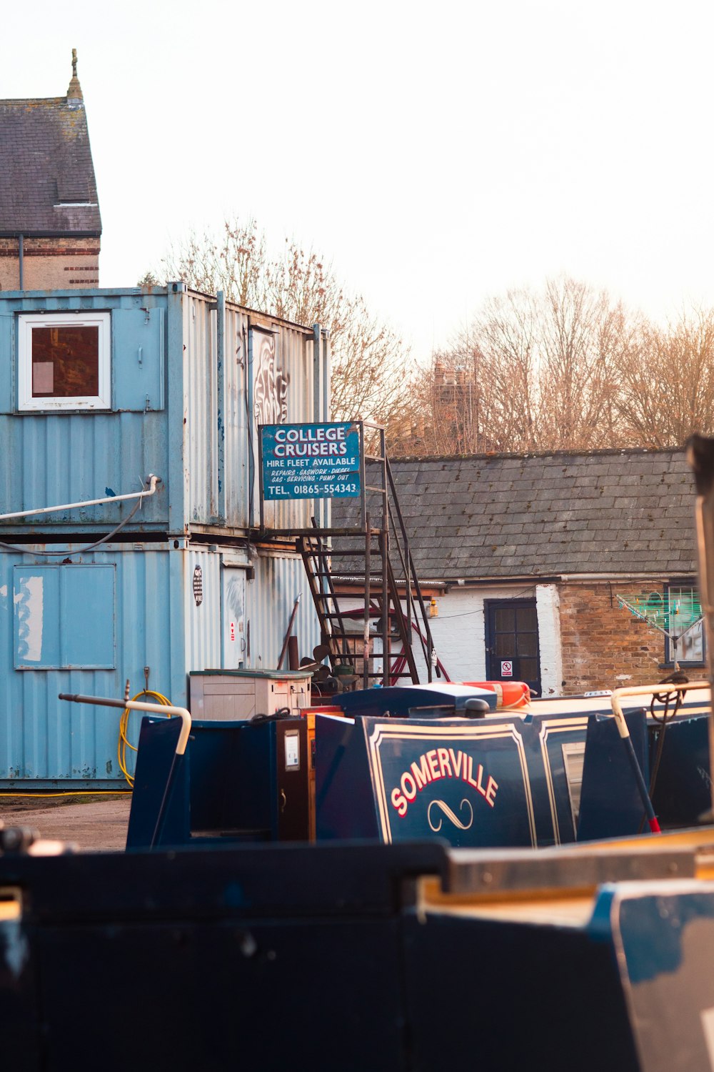 a row of blue shipping containers sitting next to a building