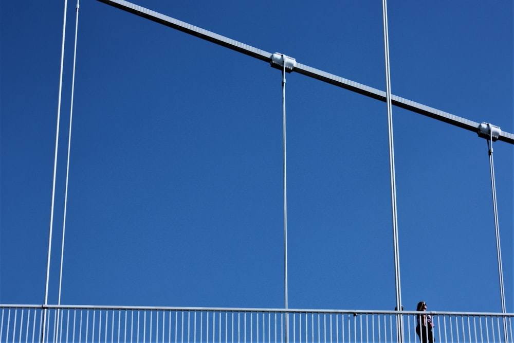 a man walking across a bridge with a kite in the air