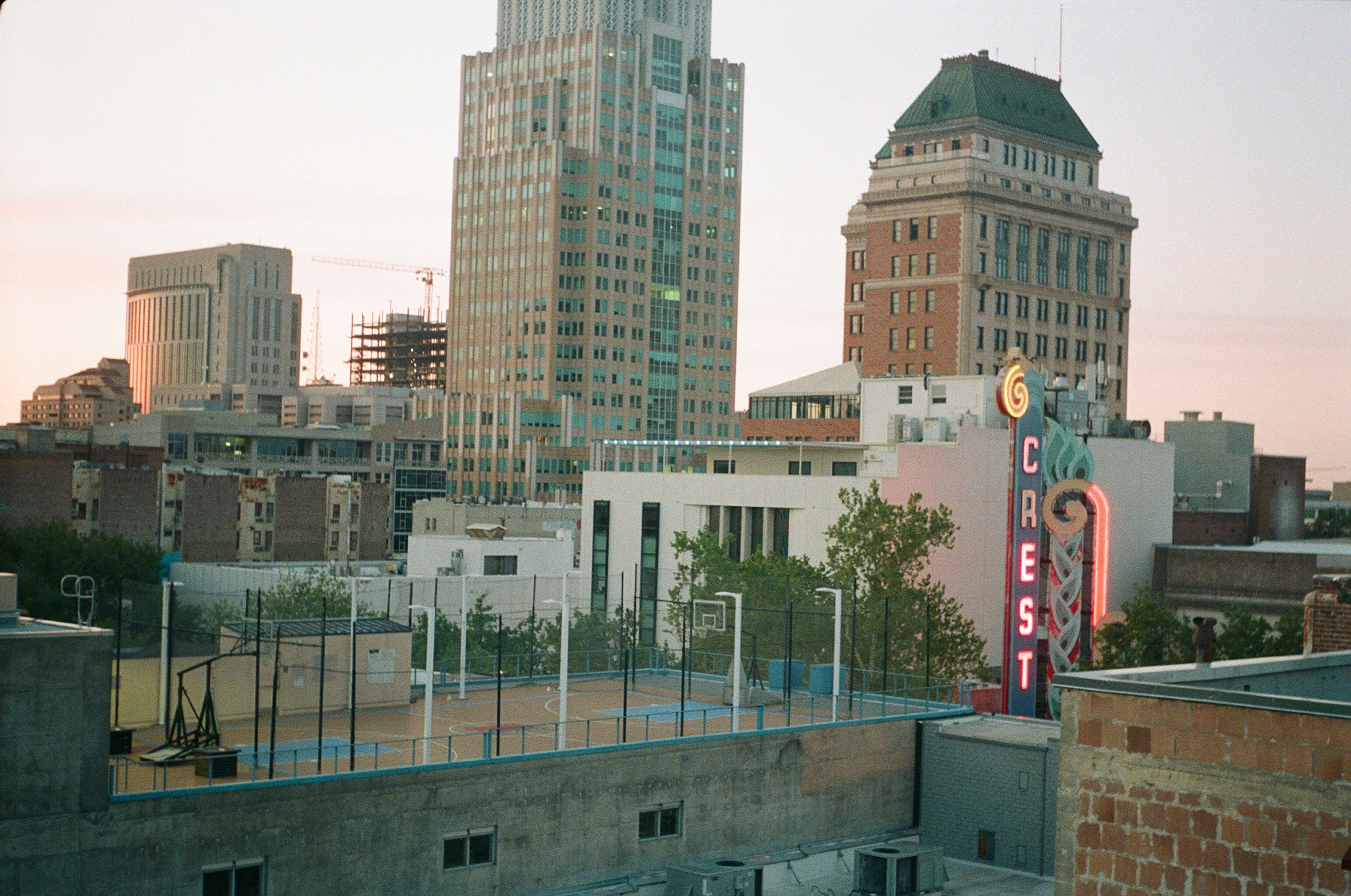 a city skyline with tall buildings and a neon sign