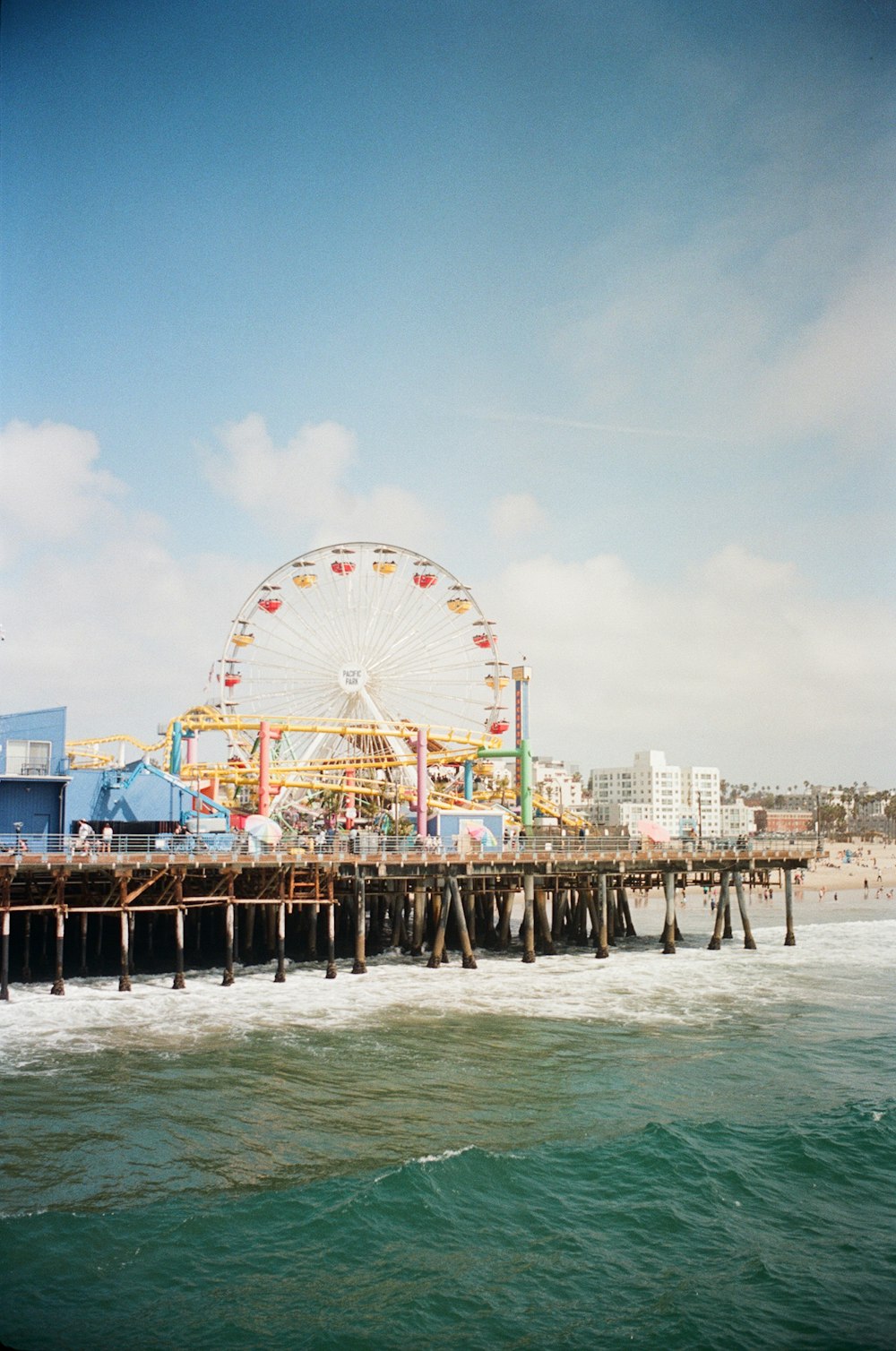 a ferris wheel sitting on top of a pier next to the ocean