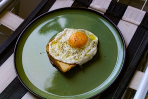 a green plate topped with an egg and toast