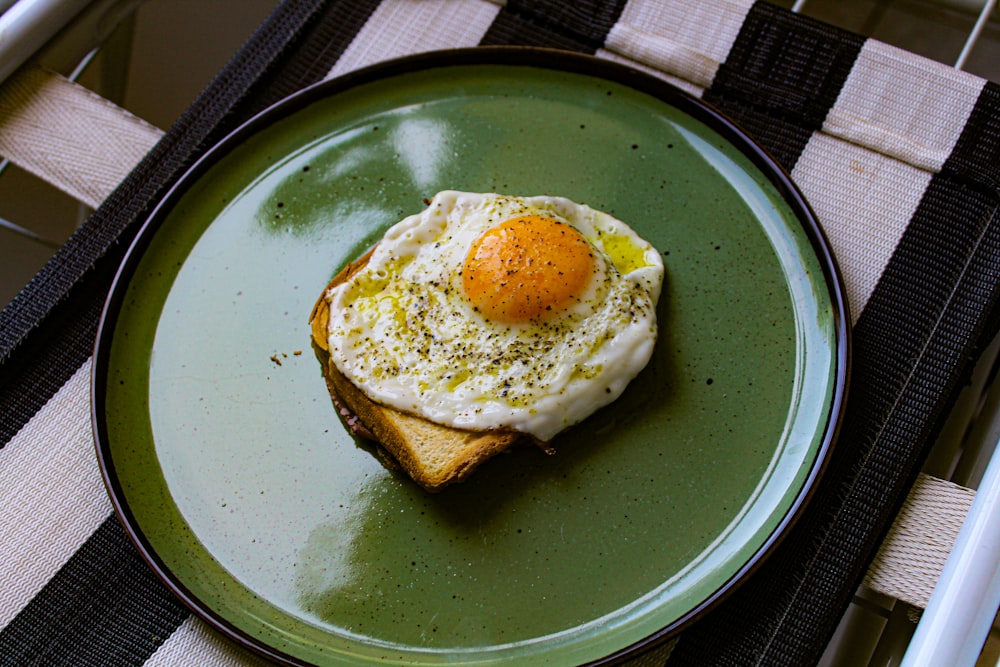 a green plate topped with an egg and toast