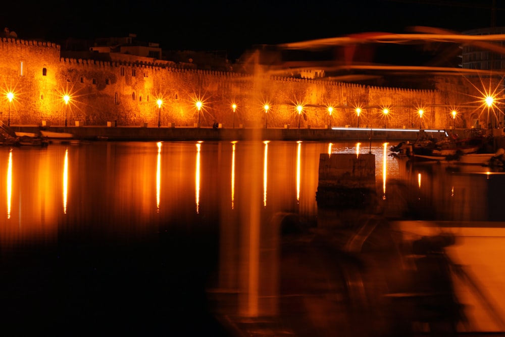 a body of water at night with lights reflecting off the water