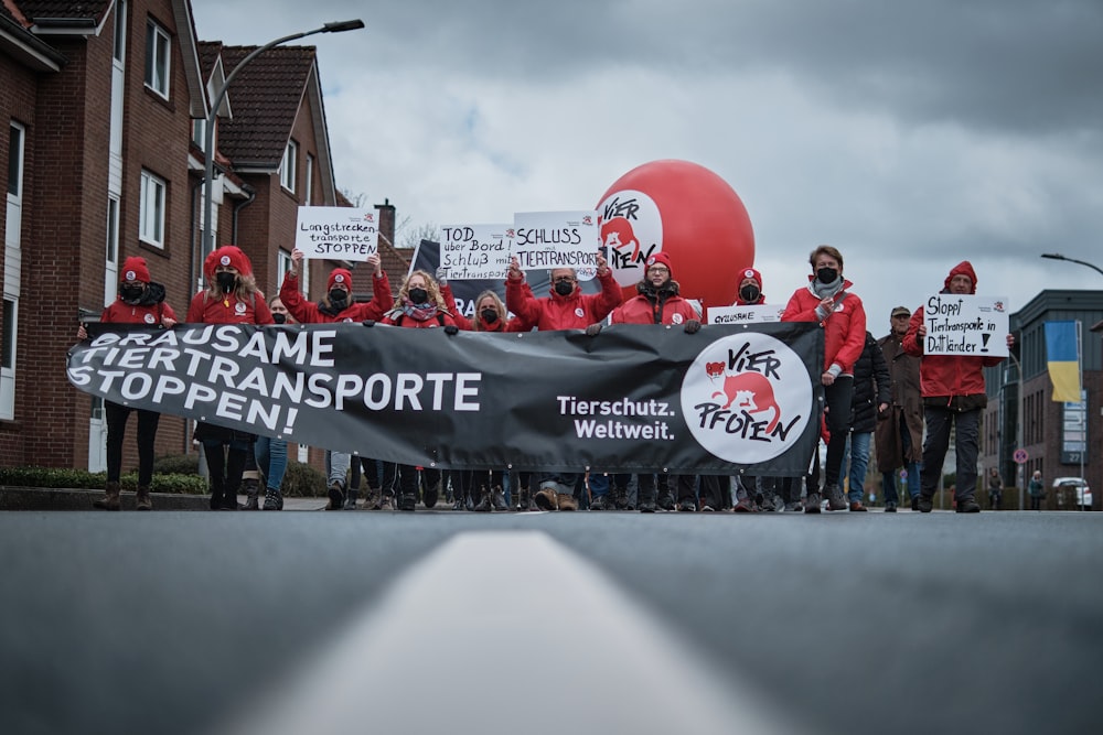 a group of people holding a banner and balloons