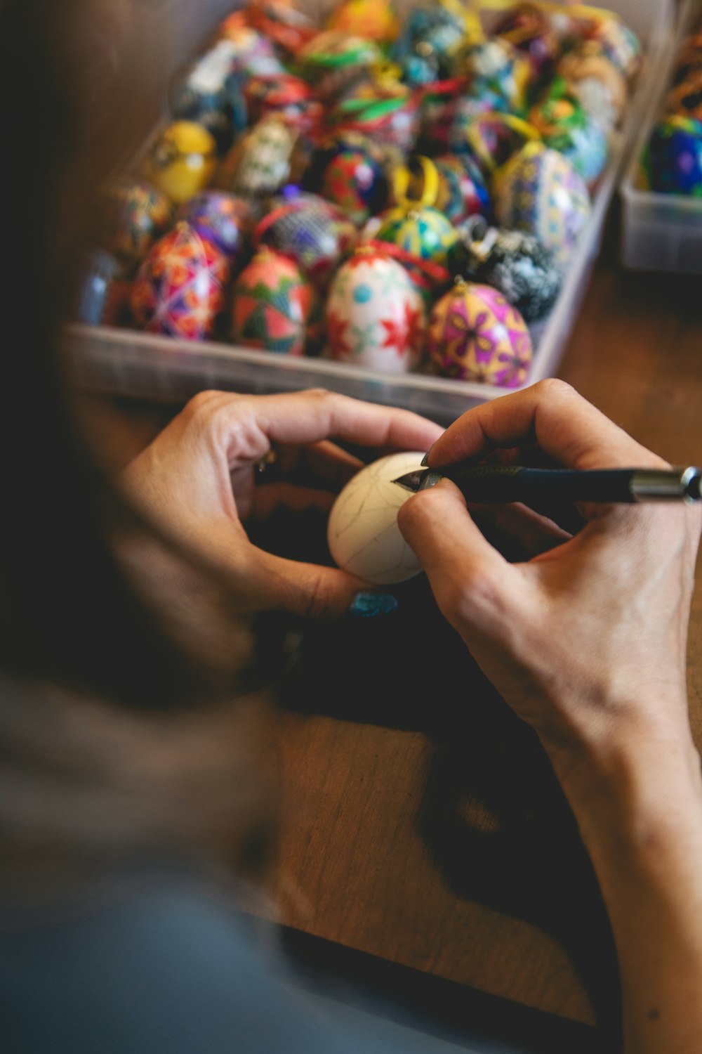 a person is using a marker to draw on some easter eggs