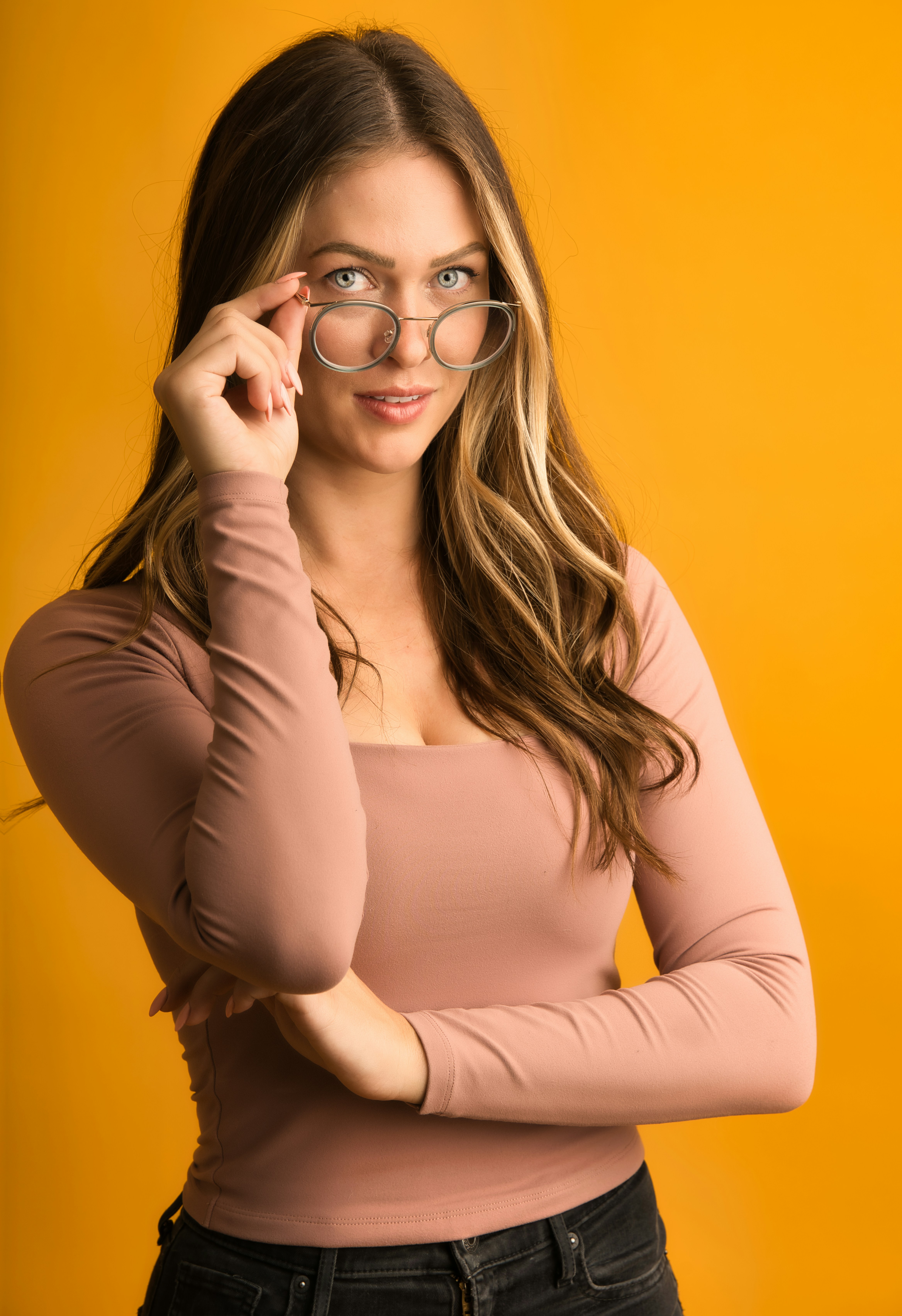 a woman wearing glasses and a pink shirt
