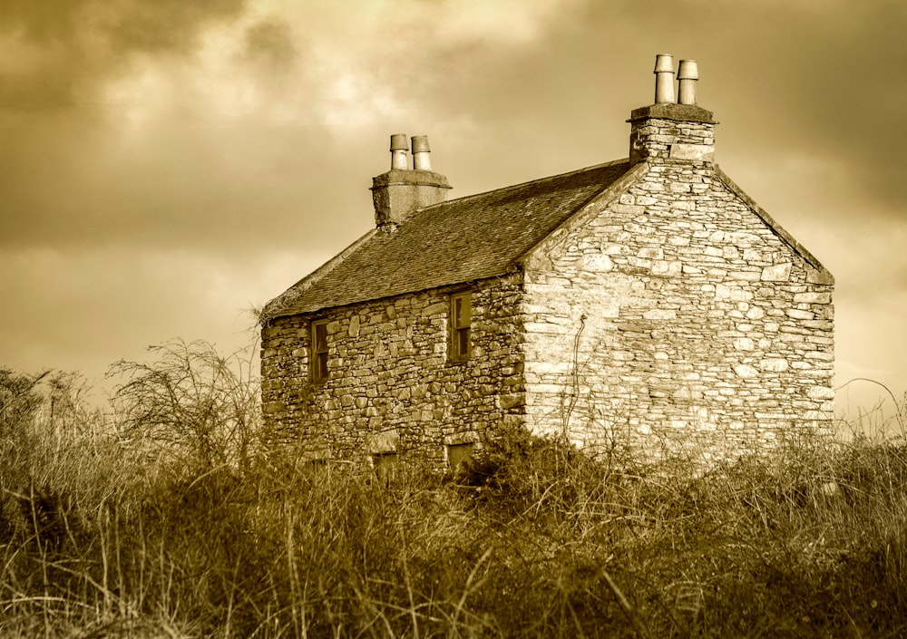 an old stone building in a grassy field