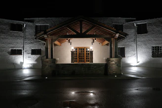 Night view of a townhouse with well-lit facade and welcoming entrance