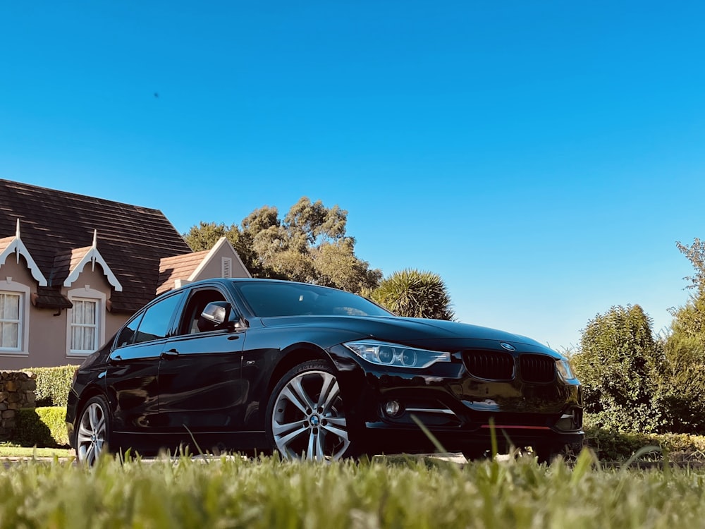 a black car parked in front of a house