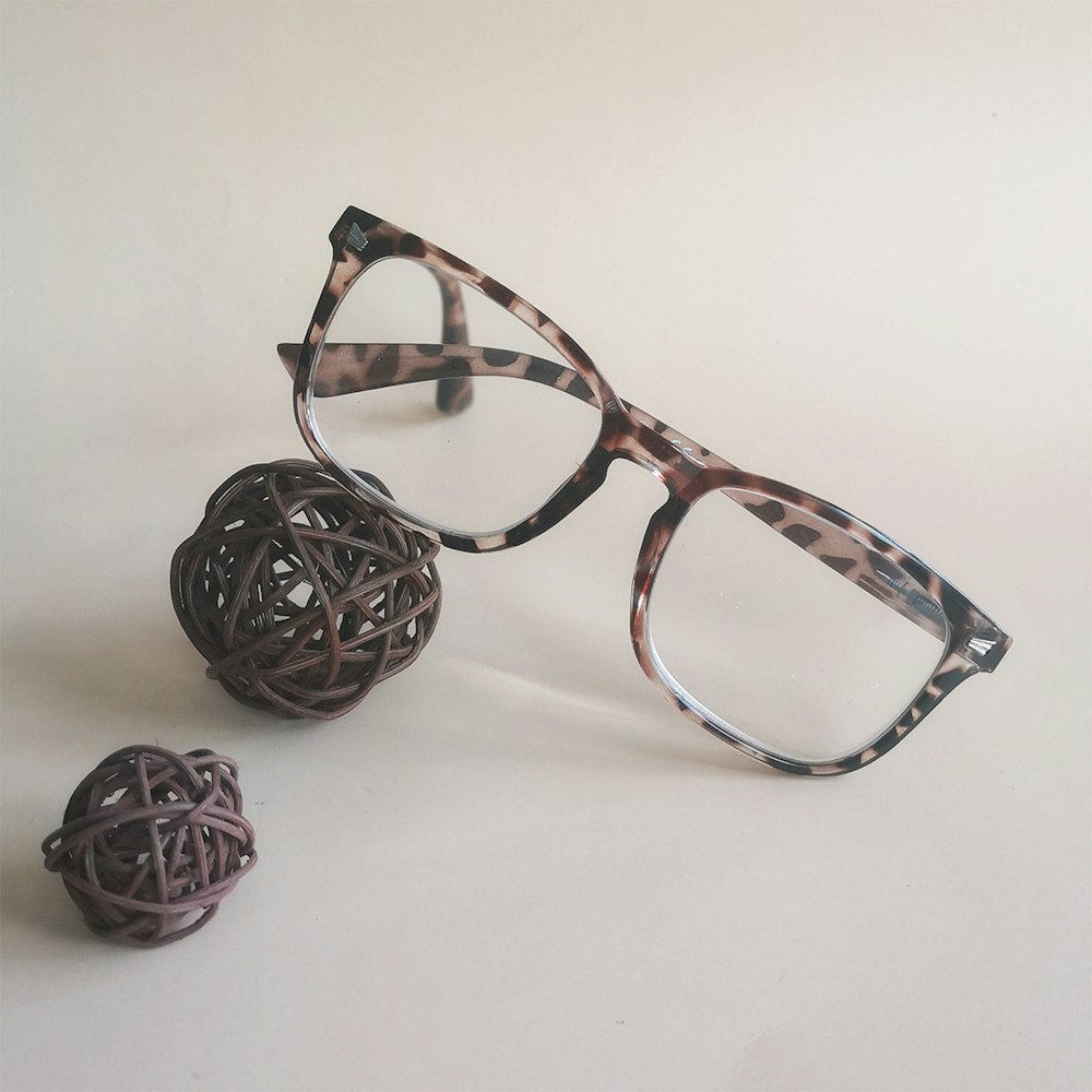 a pair of glasses sitting next to a ball of yarn