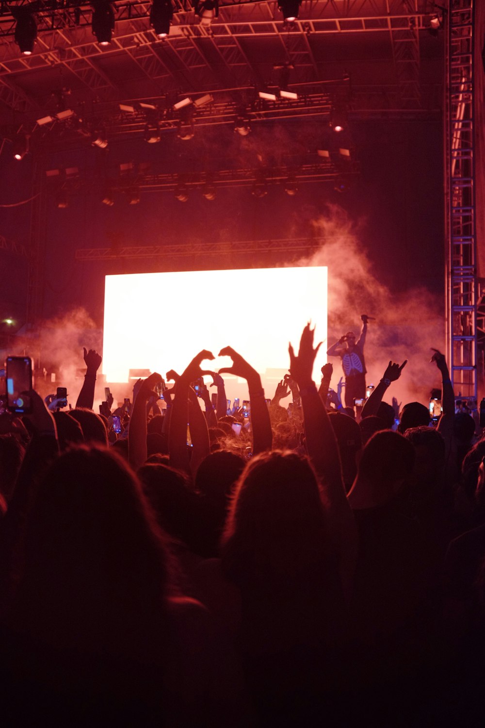 Une foule de gens à un concert les mains en l’air