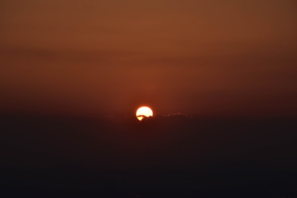 the sun is setting over the horizon of a body of water