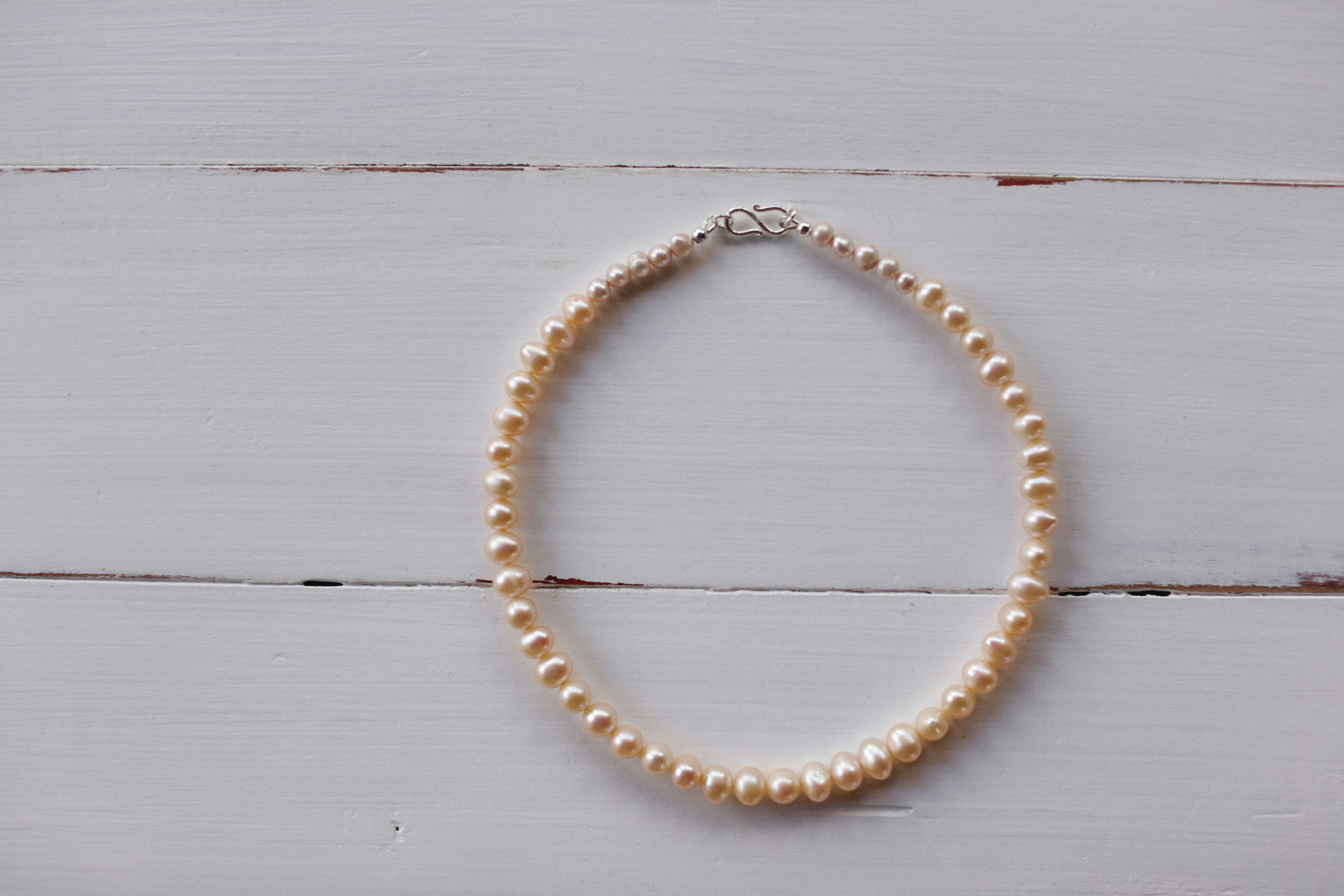 a single strand of white pearls on a white background