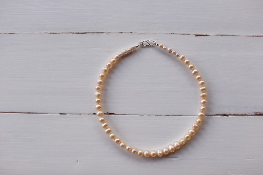 a single strand of white pearls on a white background