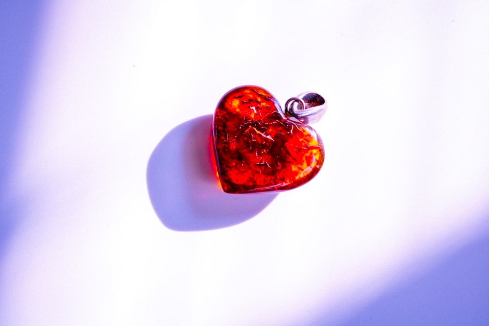 a red heart shaped object sitting on top of a table