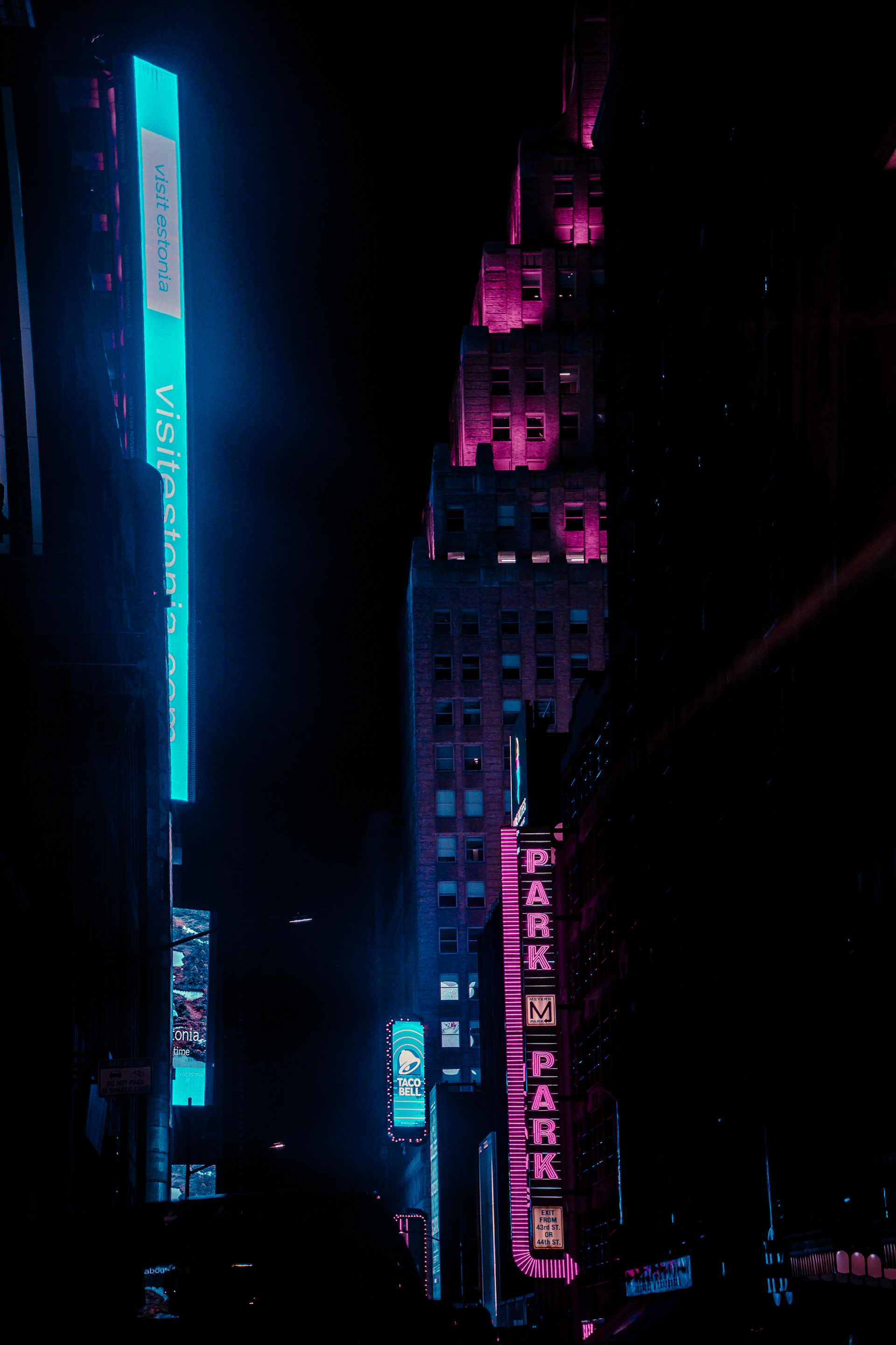 a city street at night with neon signs