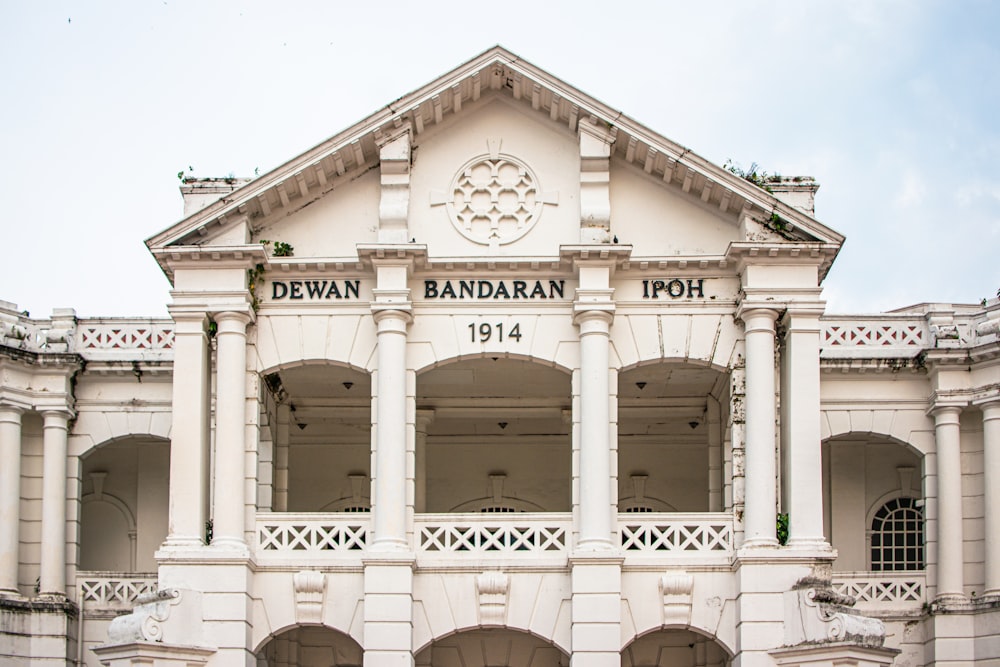 a large white building with a clock on the front of it