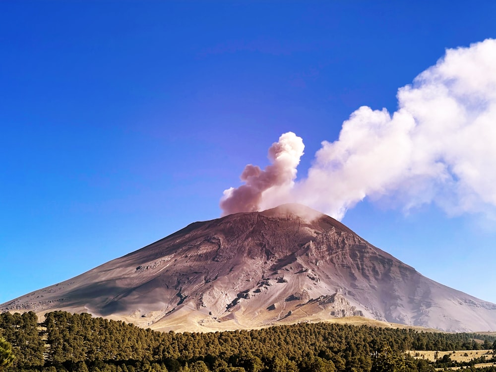 una montaña con una columna de humo saliendo de ella