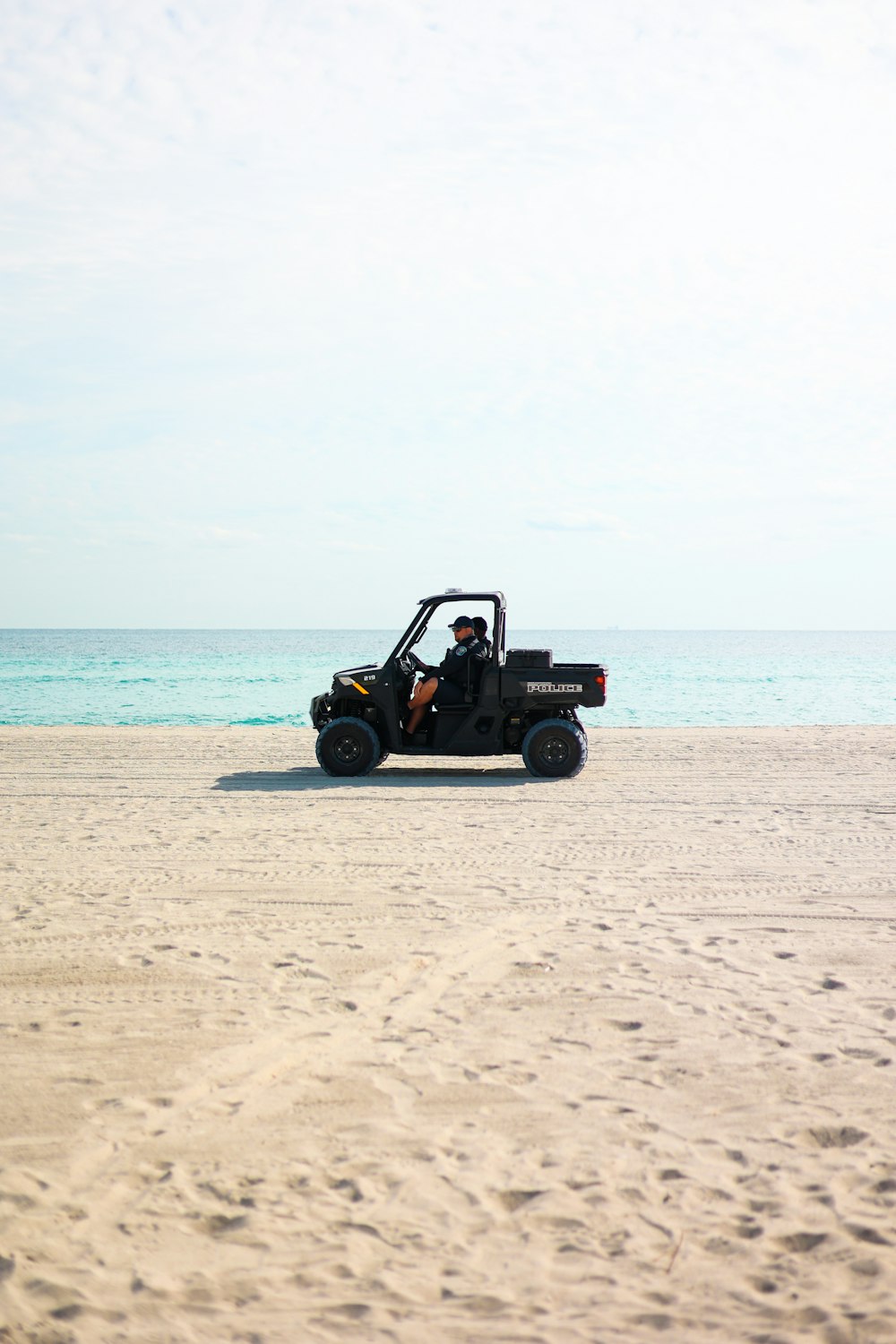 a man driving a buggy on the beach
