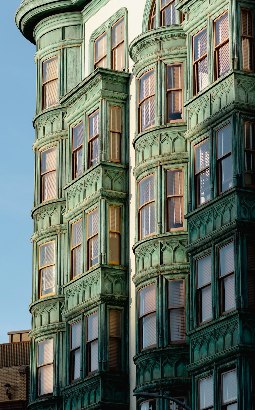 a tall green building with lots of windows