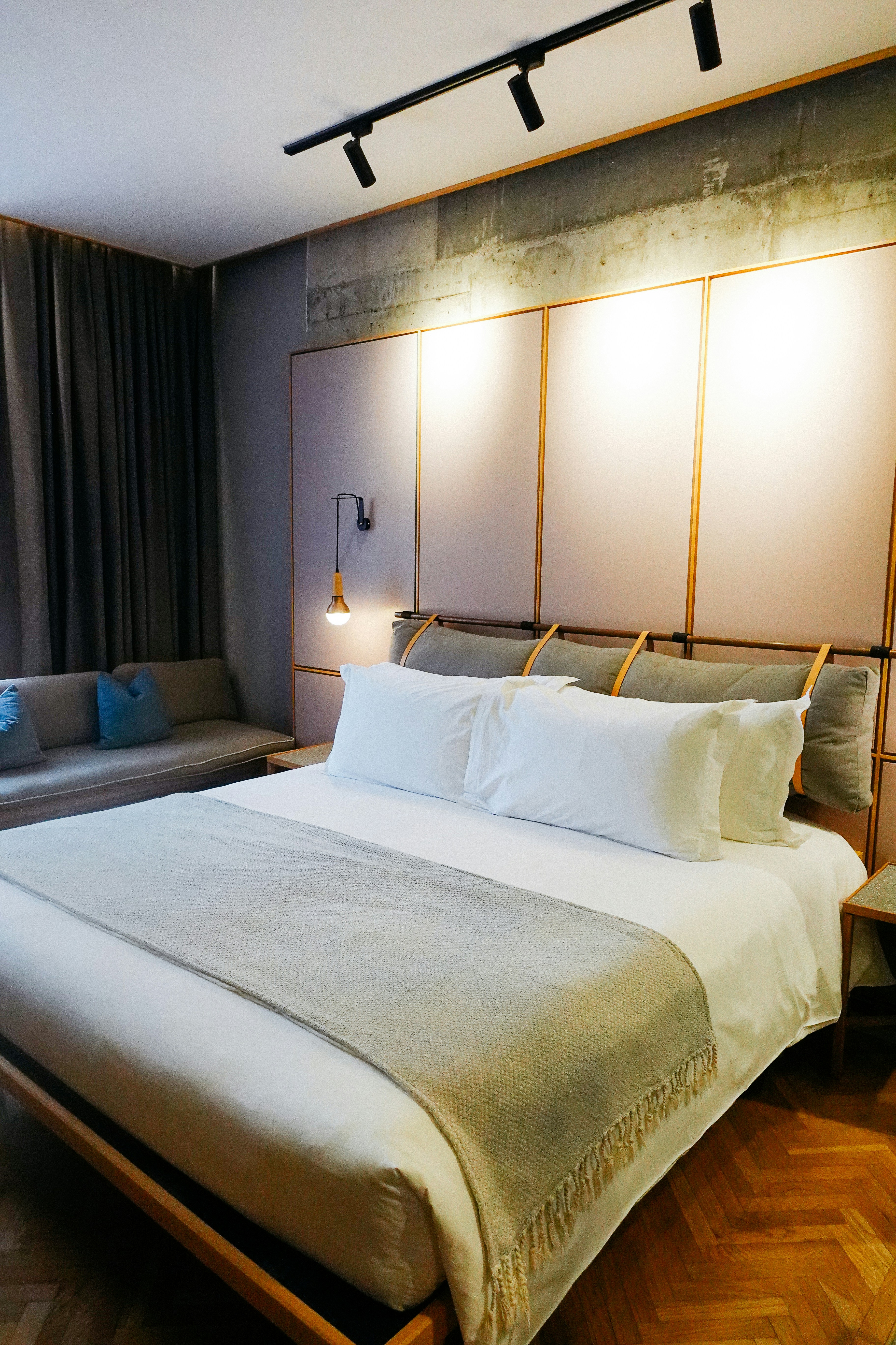 Comfortable hotel room with large bed, modern furnishings, and warm ambient lighting
