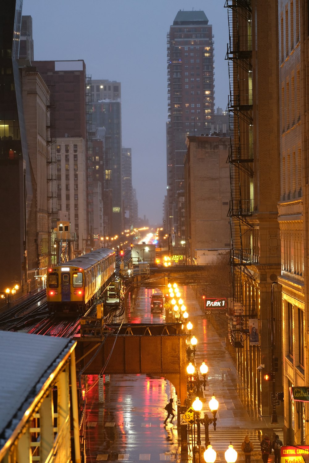 a city street at night with a train on the tracks