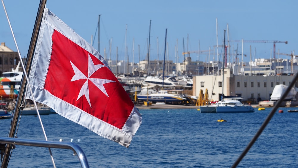 a red and white flag on a boat in the water
