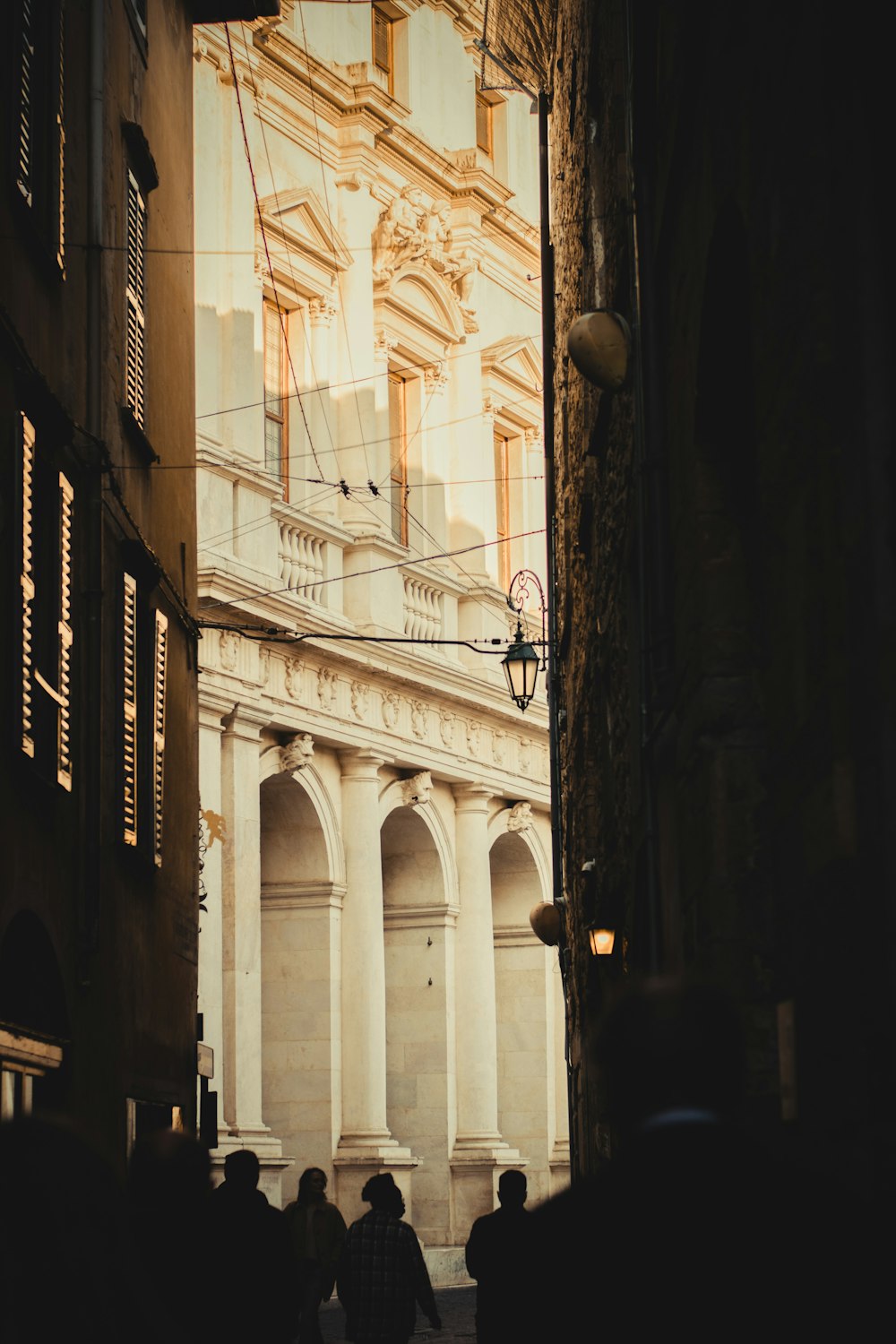 a group of people walking down a street next to tall buildings