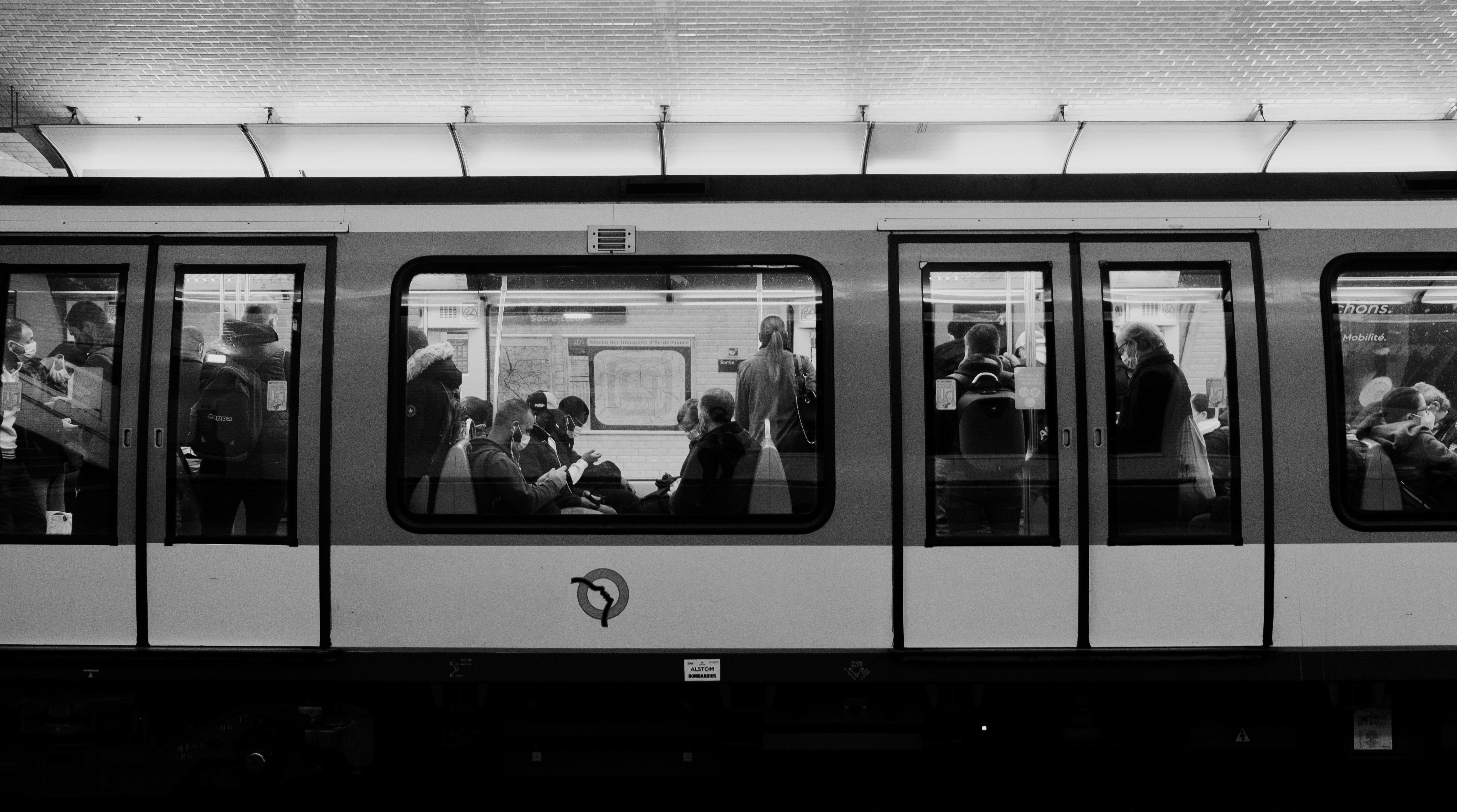 a black and white photo of people on a train, 