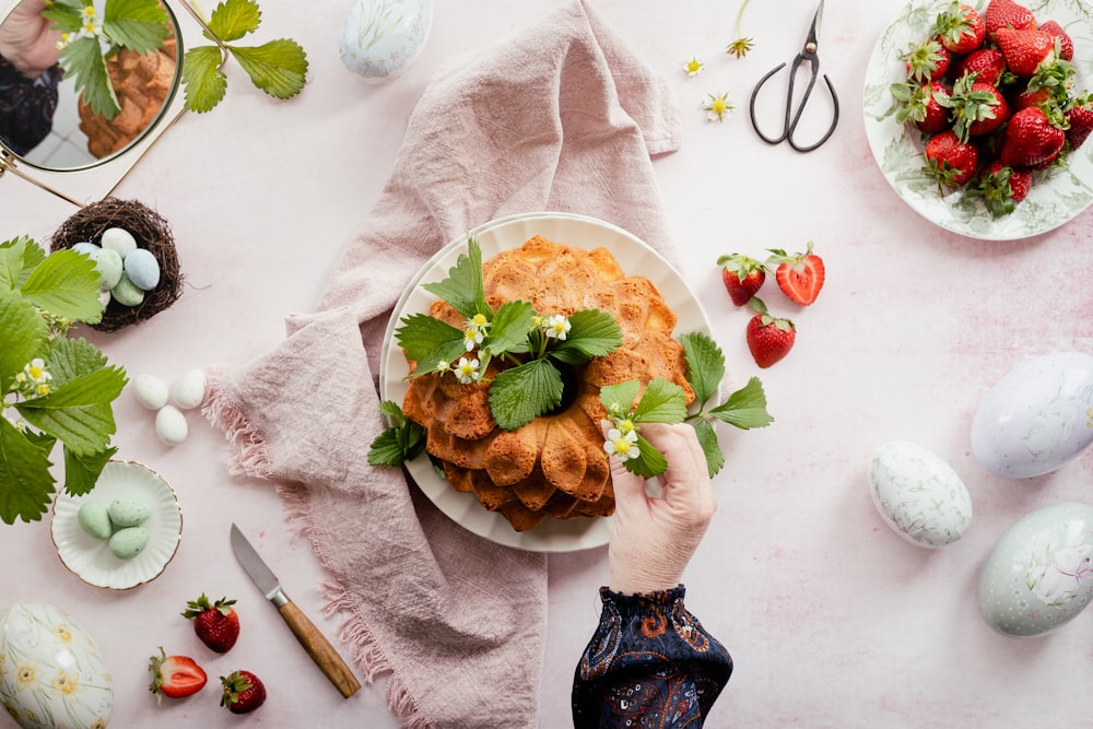 a person holding a plate of food on a table