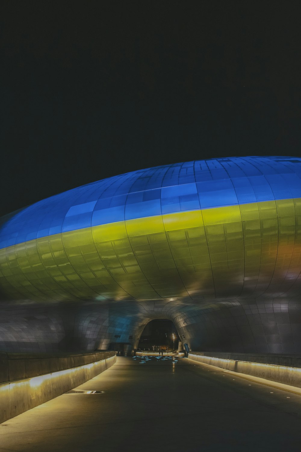a large blue and yellow balloon sitting on the side of a road