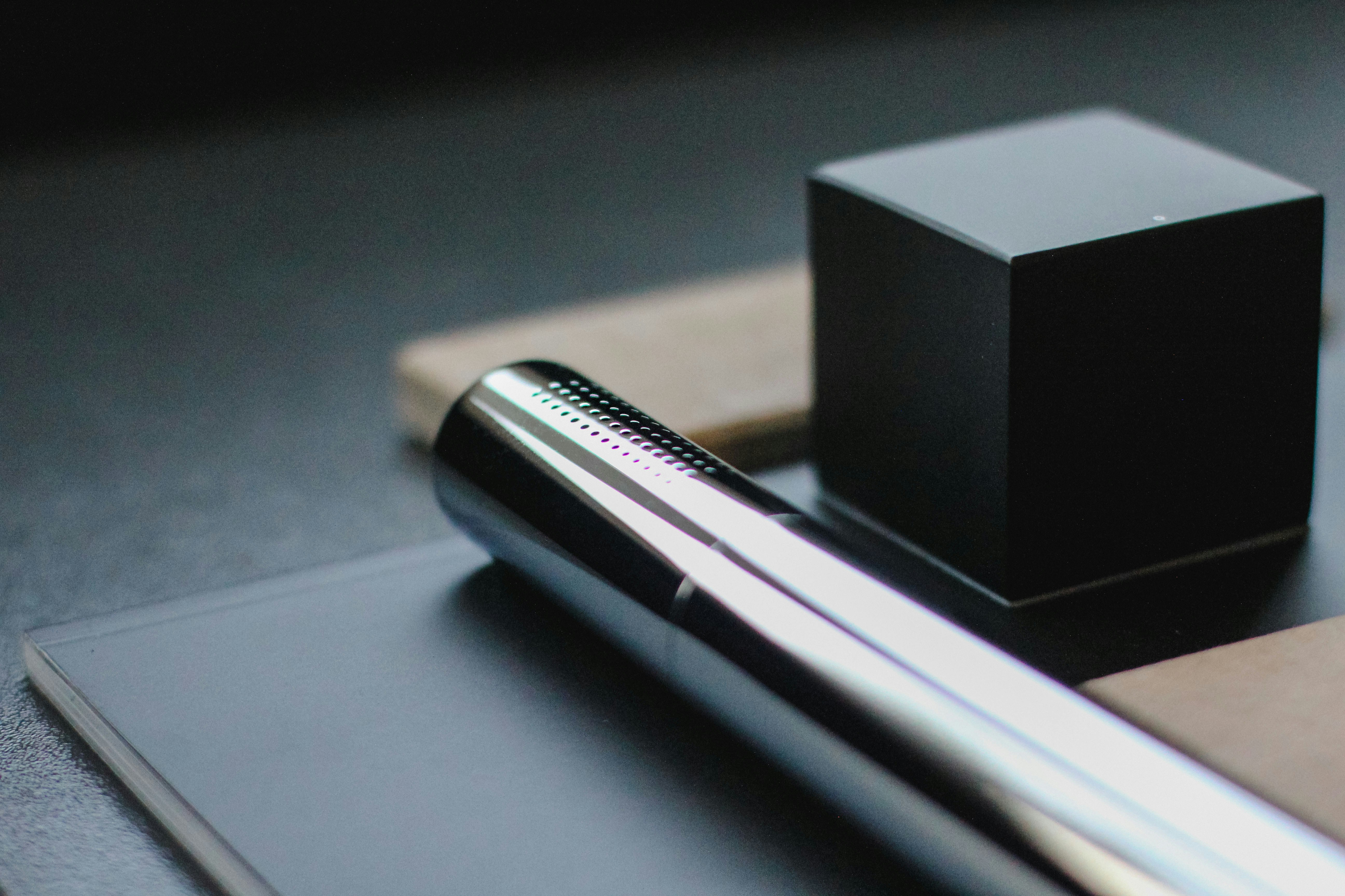 a pen sitting on top of a notebook next to a box