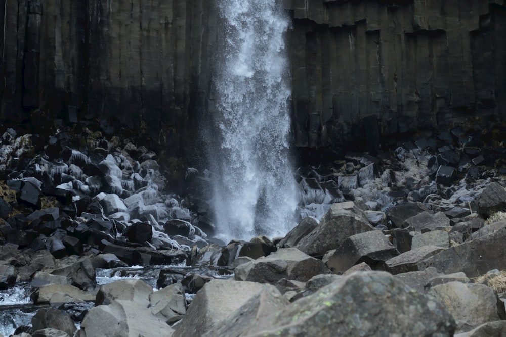 a large waterfall is coming out of the rocks