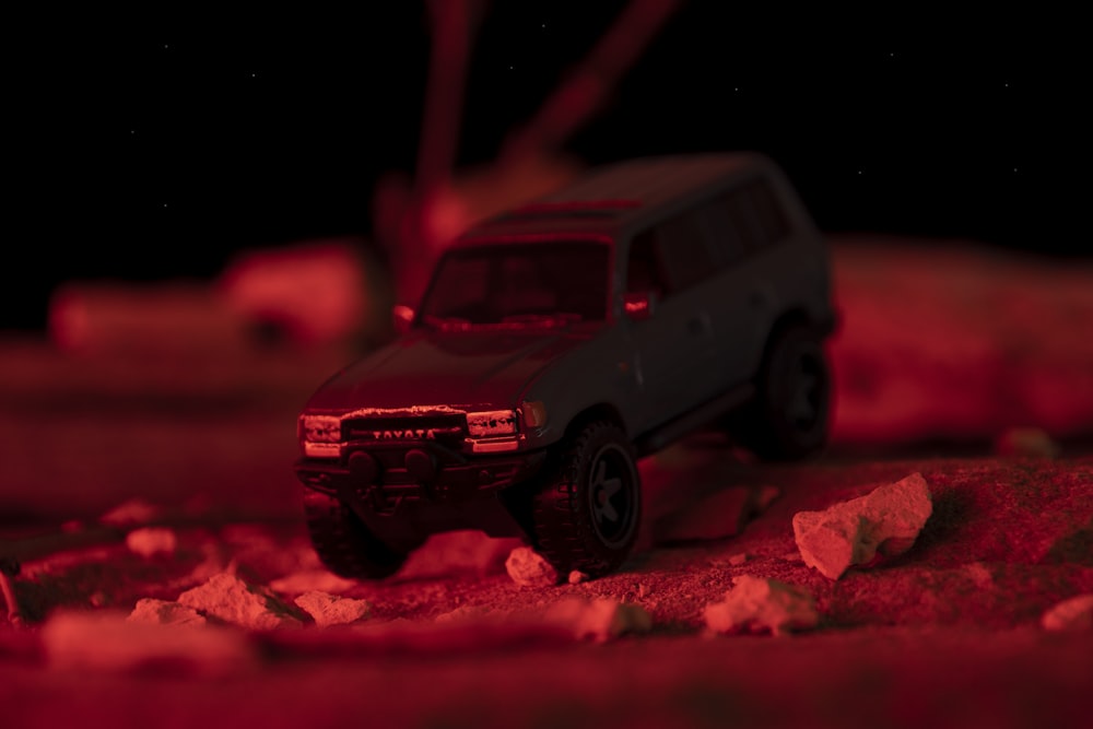 a toy truck sitting on top of a pile of rocks