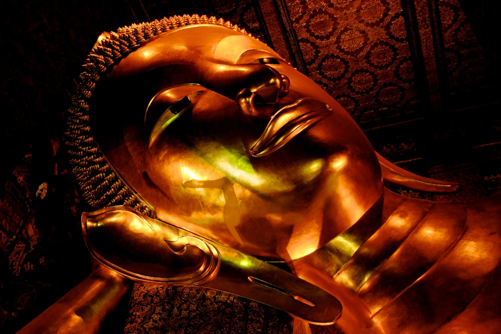 a golden buddha statue sitting in front of a wall