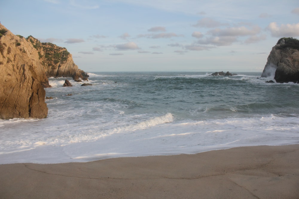 a sandy beach with waves coming in to shore