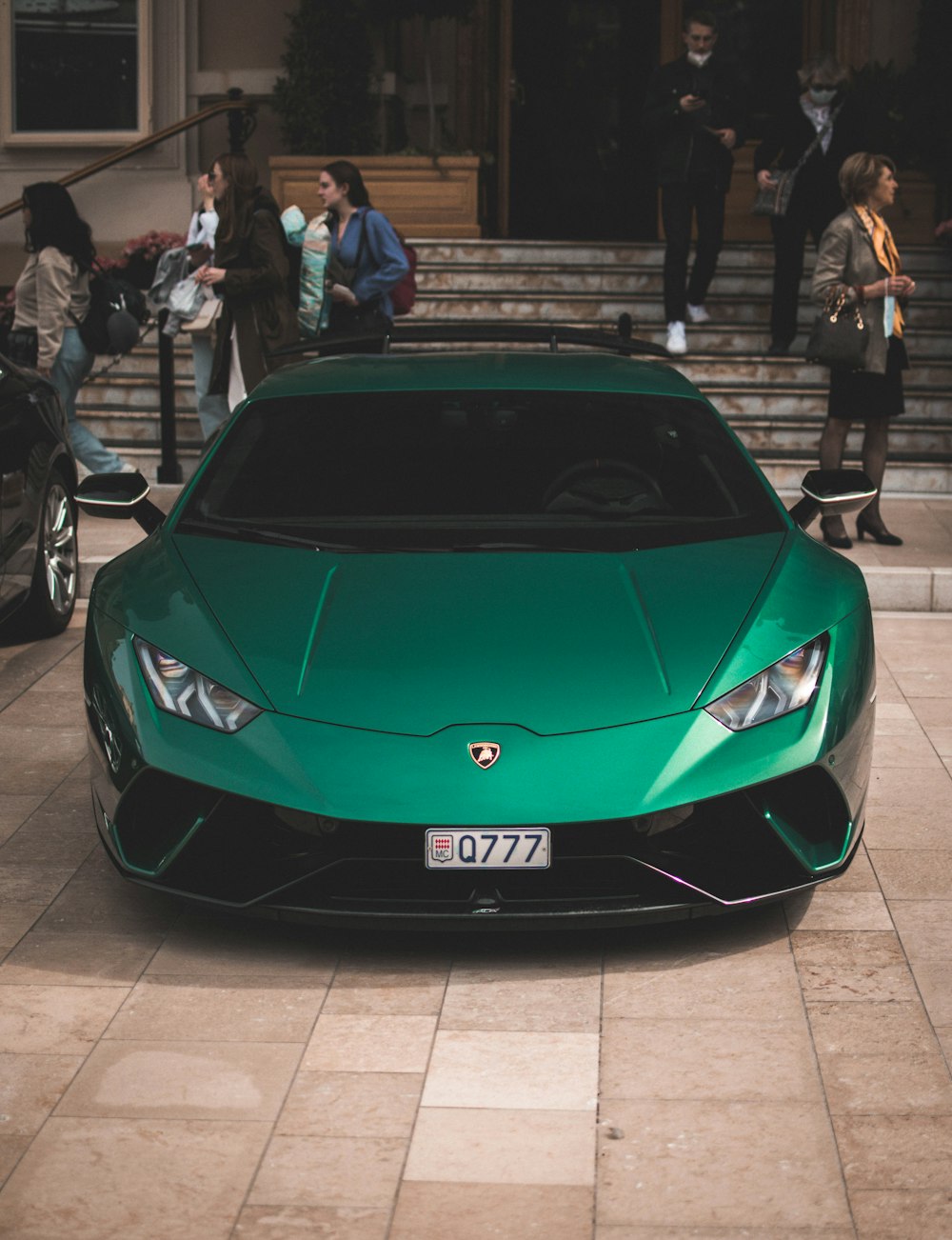 a green sports car parked in front of a building