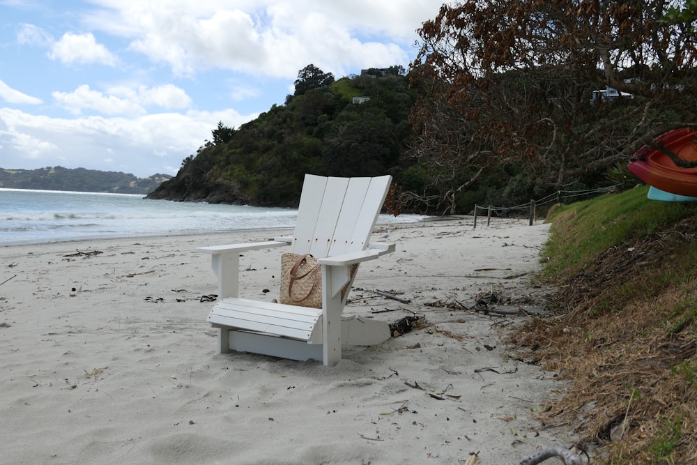 a white chair sitting on top of a sandy beach