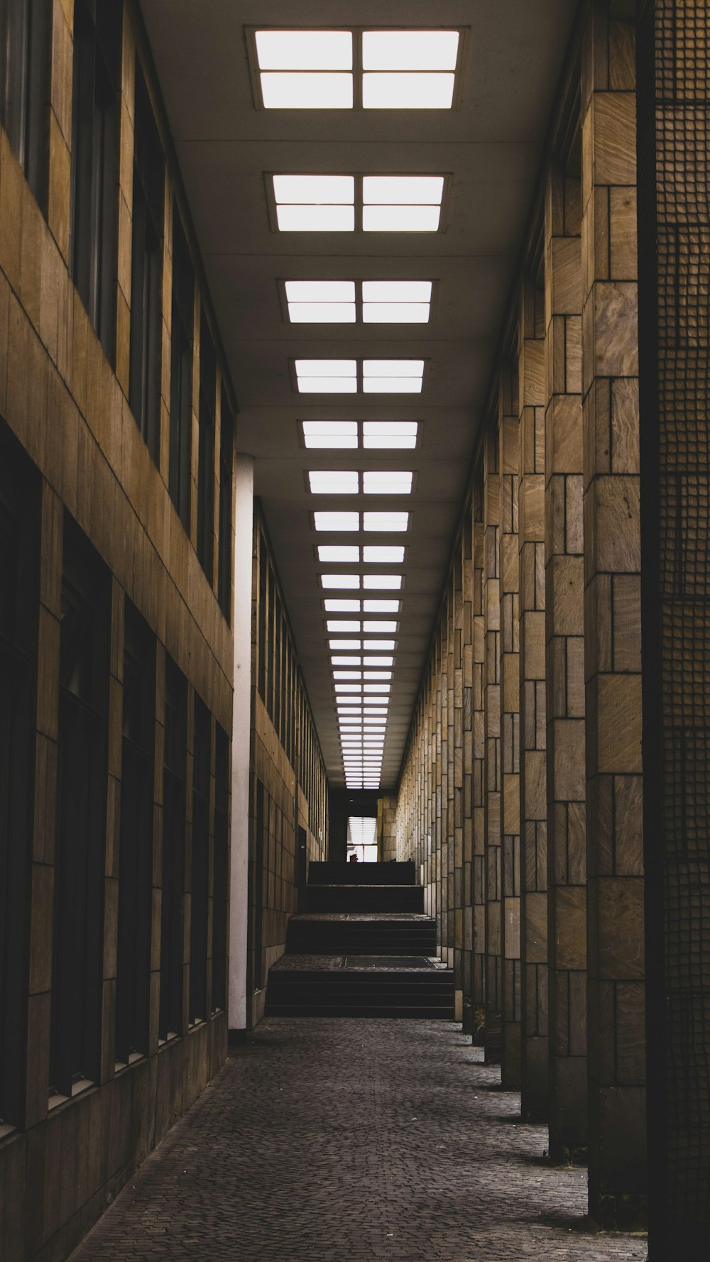 a long hallway lined with stone walls and windows