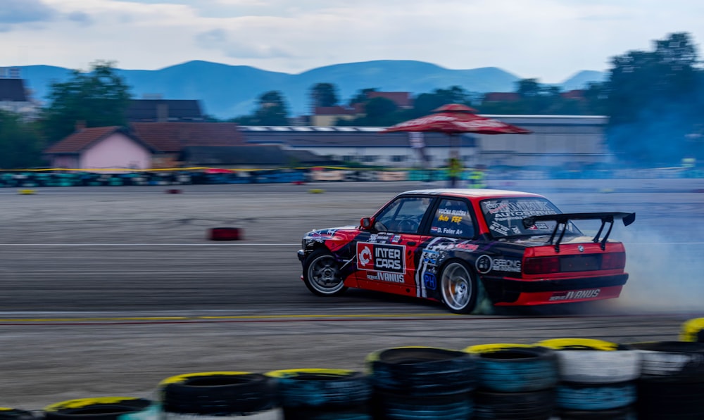 a car with smoke coming out of it driving on a track