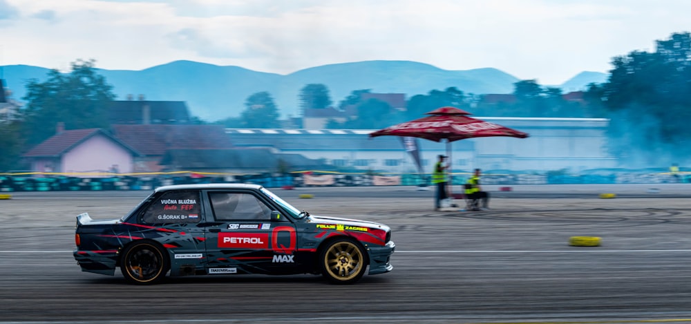 a small car driving around a track with smoke coming out of it