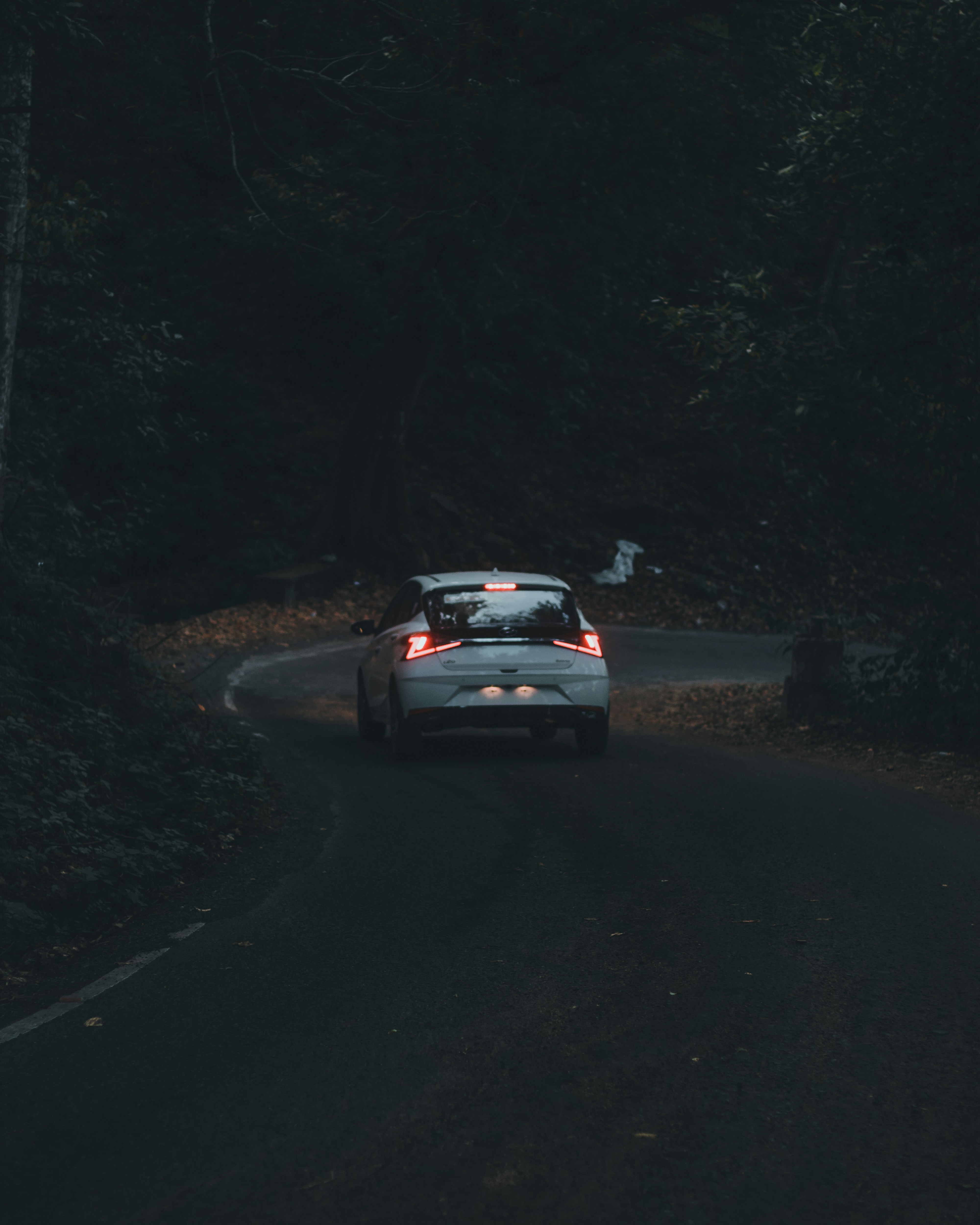 a car driving down a road in the dark