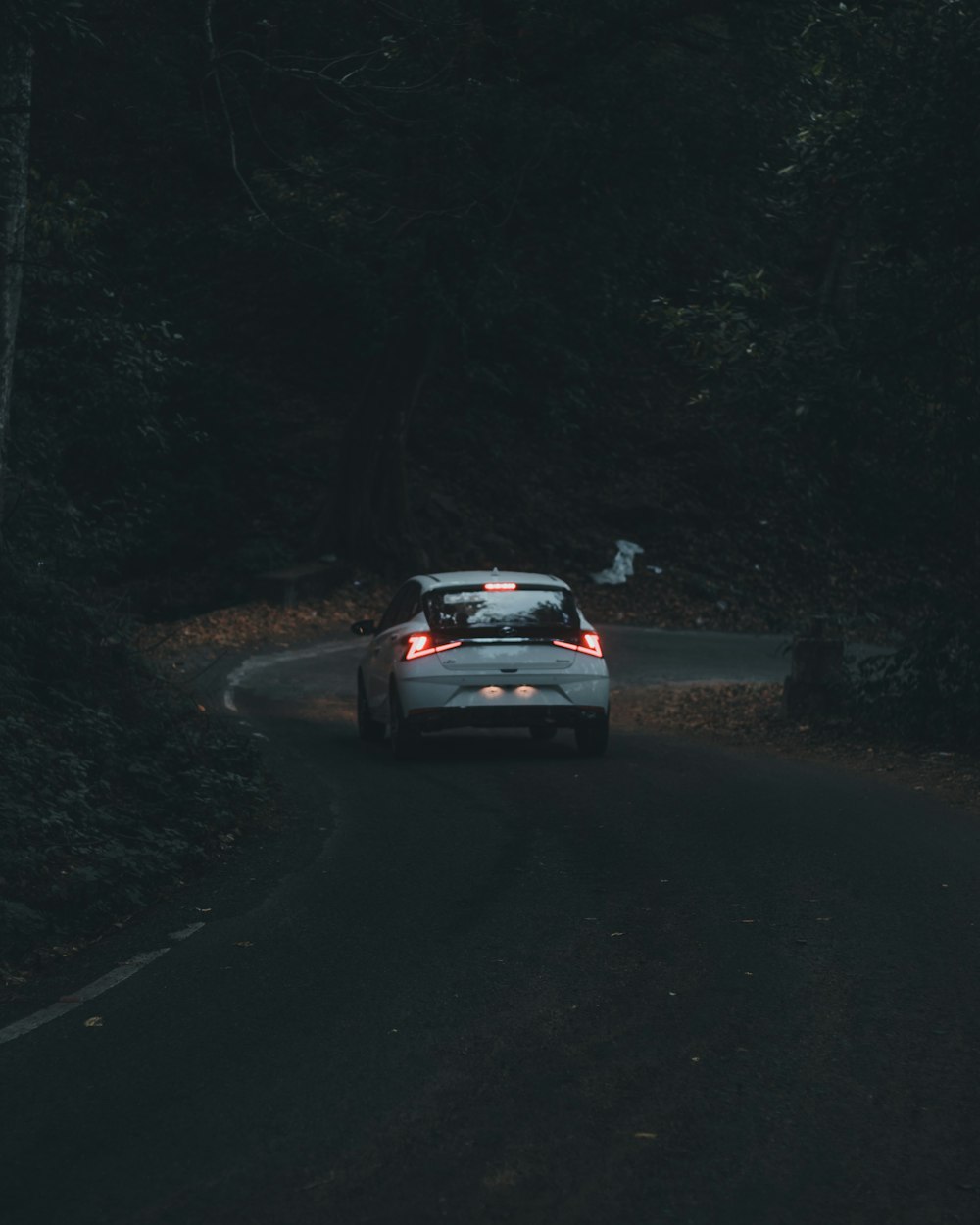 a car driving down a road in the dark